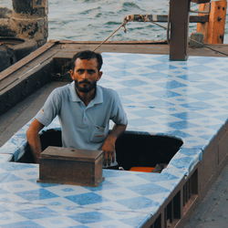 Portrait of young woman sitting on wall