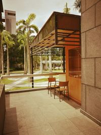 Empty chairs outside house against sky