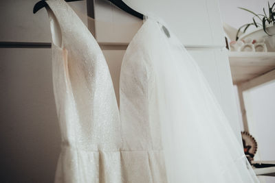 Low angle view of wedding dress hanging on cabinet