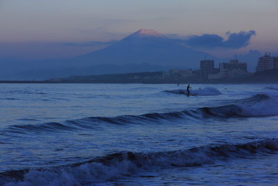 Silhouette man surfing in the sea