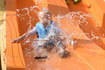 Close-up of child on water slide
