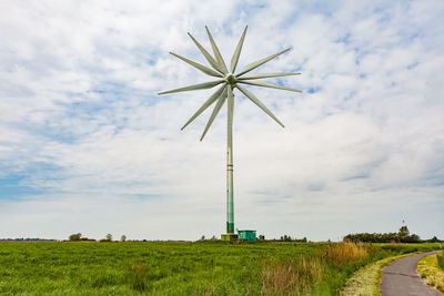 Windmill on field against sky