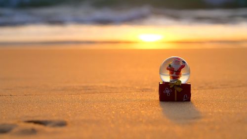 Close-up of toy on sand at beach during sunset