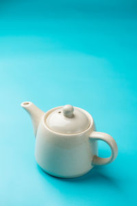 Close-up of coffee cup on table against blue background