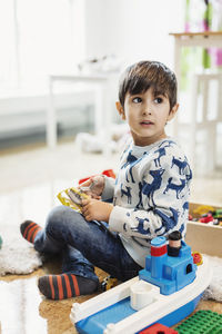 Boy looking away while playing with toys at preschool