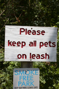 Close-up of information sign against trees