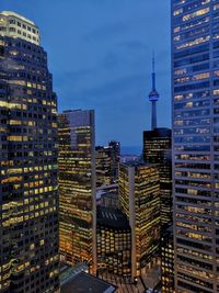 Illuminated buildings in city against sky