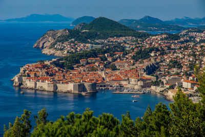 High angle view of townscape by sea against sky
