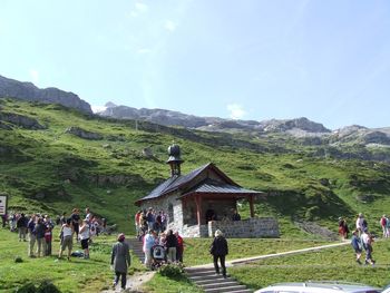 People on mountain against sky