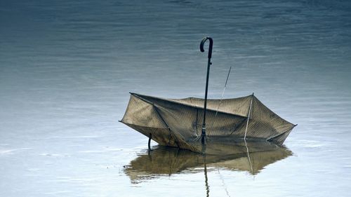 Boat floating on lake against sky