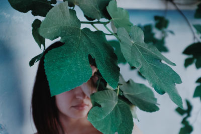 Close-up portrait of woman with leaves