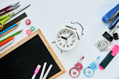 Directly above shot of writing slate with school supplies on table