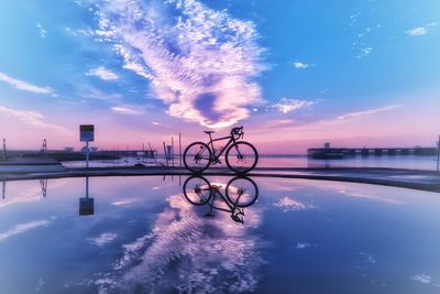 Bicycles on lake against blue sky