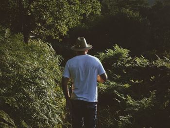 Rear view of woman standing in forest