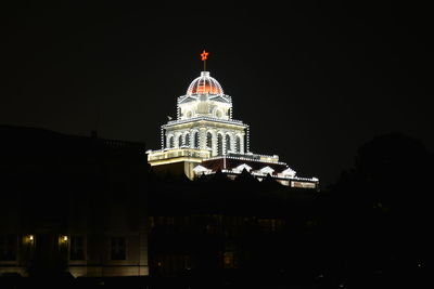 Low angle view of illuminated building against sky at night