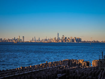 Panoramic view of sea and buildings against clear blue sky