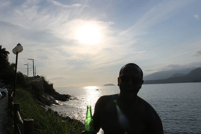 Rear view of man on beach against sky