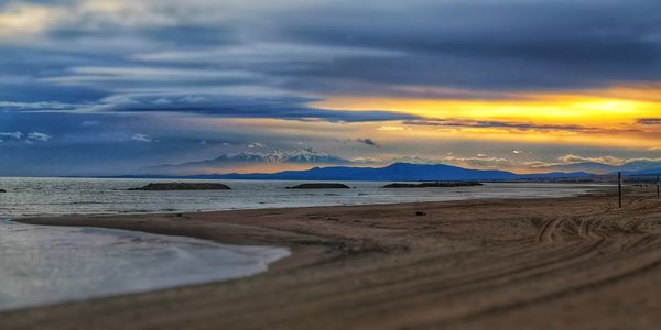 Scenic view of beach against sky during sunset