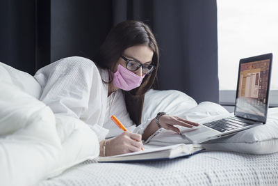Midsection of woman using phone while sitting on table