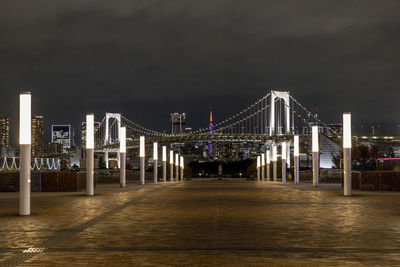 Illuminated bridge over river at night