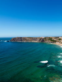 Scenic view of sea against clear blue sky