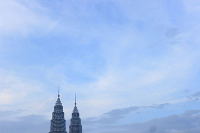 High section of petronas towers against sky