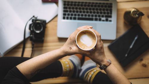 Low section of woman holding coffee cup