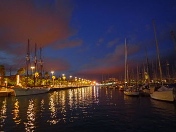 Boats moored at harbor during sunset