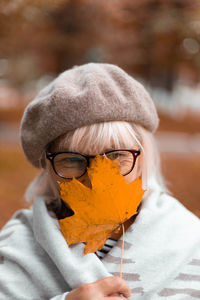 Portrait of woman holding autumn leaves