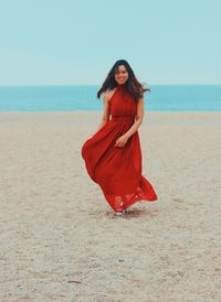 Woman wearing sunglasses on beach against sky