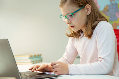 Cute girl using laptop at home