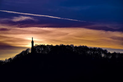 Silhouette trees and buildings against sky during sunset