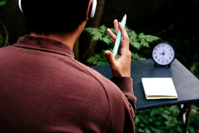 Rear view of man holding book