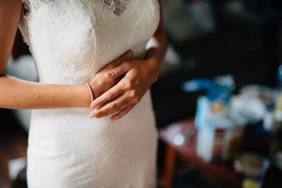 Midsection of bride standing at home