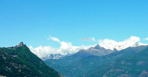 Scenic view of snowcapped mountains against blue sky