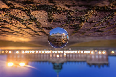 Upside down image of illuminated crystal ball against sky at night