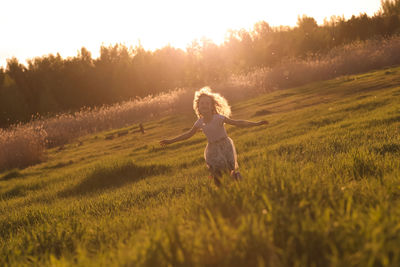 Full length of woman on field during sunset