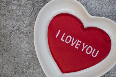 Close-up of red heart shape with text on white background