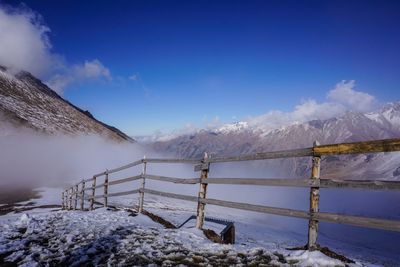 Scenic view of snowcapped mountains against blue sky