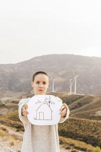 Portrait of boy standing on land against sky