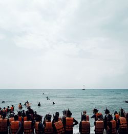 Group of people on beach against sky