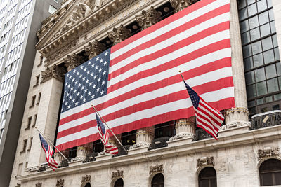 Low angle view of flag against buildings in city