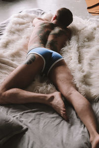 High angle view of man sleeping on bed