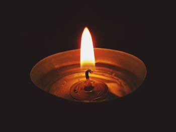 Close-up of lit candle in dark room