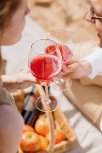 Midsection of woman holding wineglass  couple of a man and a woman walk