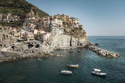 Aerial view of townscape by sea against sky