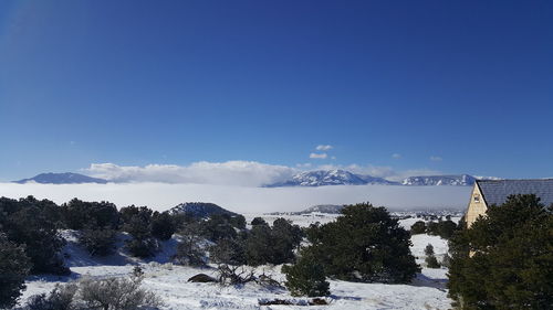 Scenic view of snow covered mountains against cloudy sky