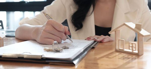 Midsection of woman holding umbrella on table