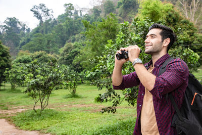 Full length of a man photographing through camera