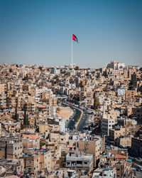 Aerial view of buildings in town against clear sky